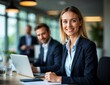 © Unlimited Resources - Professional Businesswoman Blonde Hair Bright Smile Navy Blue Blazer Office Setting Laptop Conference Room Corporate Atmosphere Confident Pose Career Success Leadership Modern Workspace