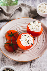 Wall Mural - Tomatoes stuffed with cottage cheese and dill on a plate on the table vertical view