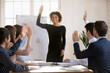 © fizkes - Multiethnic team voting unanimously during training in board room, raising hands voting for new project plan, make joint decision, take part in briefing event in office. Teamwork, election, engagement