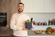 © Pixel-Shot - Young man with vegetable scraps in compost bin in kitchen
