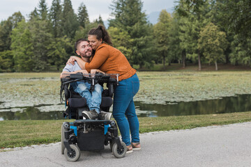 man, an electric wheelchair user in the warm embrace of his wife, a couple enjoying and showing thei