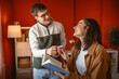 © Miljan Živković - young couple drink coffee and read book together in modern living room