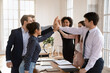 © fizkes - Multiethnic workmates giving each other high-fives, gesture of teamwork, collective achievement, celebrate reaching corporate goal, acknowledge, successful collaboration, express mutual encouragement