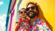 © Evgenii - A happy father and daughter in matching floral outfits and sunglasses enjoy a sunny day, smiling against a vibrant yellow wall