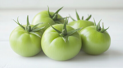 Wall Mural - Freshly harvested green tomatoes of various shapes displayed on a white table, showcasing farm-to-table produce. lutein, zeaxanthin, isoflavones, flavonoids and isothiocyanates. EGCG, an antioxidant