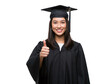 © Hung - Beautiful smiling female university graduate with thumbs up.