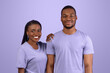 © Prostock-studio - Happy Loving Couple Concept. Front portrait of smiling black lady holding hand leaning on her boyfriend's shoulder, family of two people standing together isolated over purple violet studio background