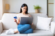 © Prostock-studio - Woman Shopping Online Using Laptop And Credit Card Sitting On Sofa At Home On Weekend. Free Space For Text
