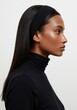 © IbragimovN - Elegant side profile of a woman in a black headband and turtleneck