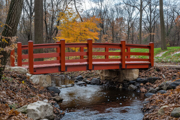 Wall Mural - A red wooden bridge spans a river with a stream of water underneath