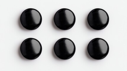 six glossy black buttons arranged in two rows, creating a simple yet striking visual pattern on a li