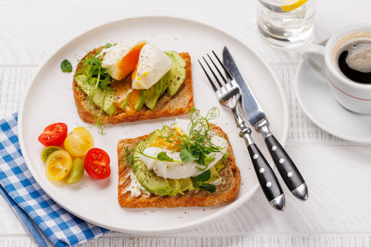 Fototapete -  - Delicious avocado toasts topped with perfectly cooked poached eggs
