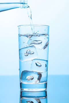 Fototapete -  - Crystal clear water being poured into a transparent glass, creating refreshing ripples and bubbles