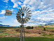 © Austockphoto - A metal windmill above a field and hilly area in south east Queensland