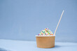 © Austockphoto - Vanilla soft serve icecream with colourful sprinkles in tub with wooden spoon