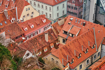 Poster - Scenic aerial view of historic European rooftops covered with red clay tiles and chimneys. Old town architecture and traditional cityscapes in European city. Panoramic view of Graz, Austria