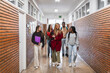 © Koldo_Studio - High school students walking and talking in school corridor