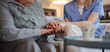 © Halfpoint - Close up of holding hands of healthcare worker and senior patient.