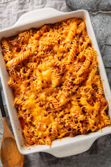 Wall Mural - Sloppy Joe Casserole made with pasta, a saucy ground beef mixture and shredded cheese closeup in the baking dish on the table. Vertical top view from above