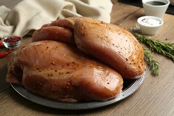 Wall Mural - Raw marinated turkey breasts on wooden table, closeup