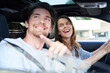 © Westend61 - Happy couple in a car with woman driving and man pointing his finger