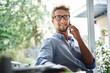 © Westend61 - Casual young businessman on the phone at desk in office