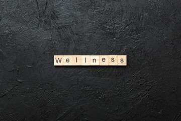 Wall Mural - Wellness word written on wood block. Wellness text on cement table for your desing, concept