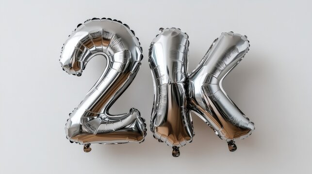 Silver 2k metallic balloons on white background celebrating milestone achievement