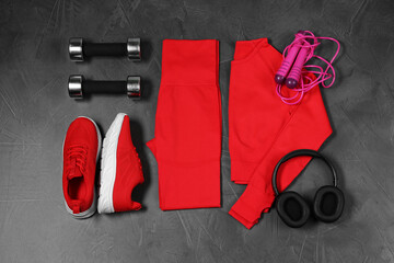 Wall Mural - Stylish sportswear, dumbbells, red sneakers, skipping rope and headphones on grey background, flat lay