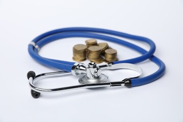 Wall Mural - Stethoscope and coins on light background, closeup