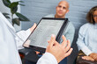 © Meeko Media - Doctor Consulting Patients Using a Digital Tablet in a Modern Clinic Setting