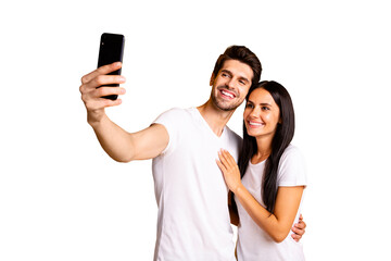 Poster - Photo of two people holding telephone in hand taking selfies for new post wear casual clothes isolated yellow color background