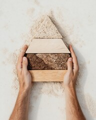 Poster - Coastal Strategy Display Hands Crafting Pyramid with Textured Wooden Blocks on Sand - Leadership Development Content and Sustainable Business Innovation