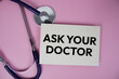 © may1985 - Ask Your Doctor text with stethoscope top view on pink background, Healthy and wellness concept
