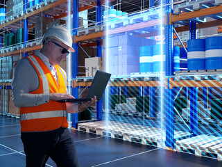 Poster - man warehouse supervisor. storekeeper is using laptop. man with computer stands in warehouse buildin