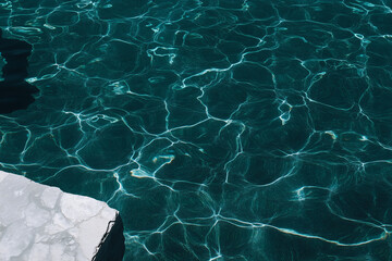 Poster - Serene Water Texture: Capturing the mesmerizing interplay of light and shadow on a water surface, a tranquil display of fluid dynamics and natural beauty. 