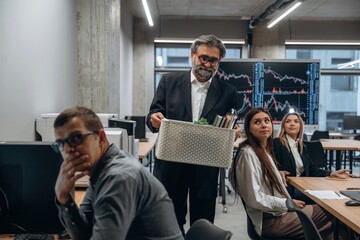 Wall Mural - Senior man is fired. Group of office workers are indoors together