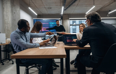 Wall Mural - Data on screen. Group of office workers are indoors together