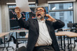 © standret - Screaming, talking by phone. Senior man is in the modern office