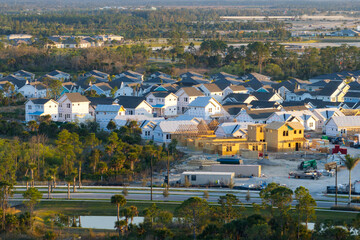 Wall Mural - Aerial view of unfinished wooden frames of affordable houses under construction. Development of residential housing in American suburbs. Real estate market in the USA