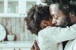 © marimalina - Emotional father and child embrace in a cozy kitchen during a quiet afternoon at home