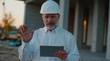 Aufkleber - Experienced engineer wearing safety helmet and glasses using tablet and gesturing while explaining project details at construction site in slow motion