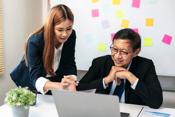 Aufkleber - A woman and a man are sitting at a desk with a laptop in front of them