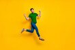 © deagreez - Full length body size photo of cheerful positive strong man running jumping demonstrating his powerful muscles wearing blue pants trousers purple t-shirt isolated over vivid color background