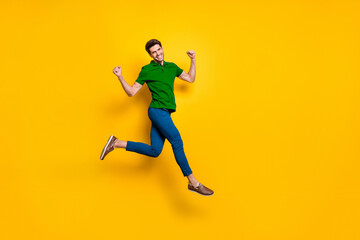 Aufkleber - Full length body size photo of cheerful positive strong man running jumping demonstrating his powerful muscles wearing blue pants trousers purple t-shirt isolated over vivid color background