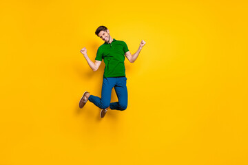 Aufkleber - Full length body size photo of cheerful positive toothy beaming buy jumping high as rejoicing about having won olympic games wearing blue pants trousers isolated vivid yellow color background