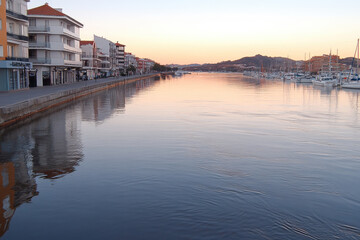 Wall Mural - A calm river with a reflection of the buildings on the water