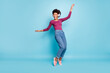 © deagreez - Full body photo of cheerful funny mulatto girl have free time listen music on her headset dance sing enjoy wear stylish green pullover denim jeans sneakers isolated over blue color background