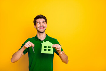 Poster - Portrait of his he nice attractive cheerful cheery dreamy guy holding in hands keys and house figure isolated over bright vivid shine vibrant yellow color background