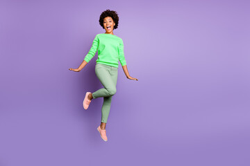 Wall Mural - Full length photo of amazed excited afro american girl jump have weekends scream wow wear casaul style outfit isolated over violet purple color background